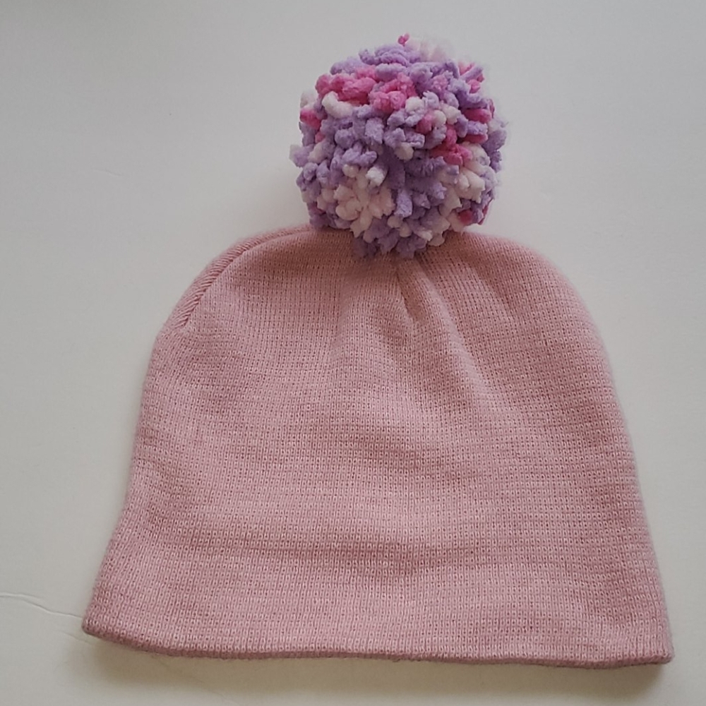Pink knit hat with multi colored pom pom